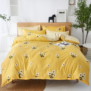 Parure de lit jaune fleurie. Bonne qualité, confortable et à la mode sur un lit dans une maison