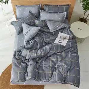 Parure de lit carreaux gris. Bonne qualité, confortable et à la mode sur un lit dans une maison