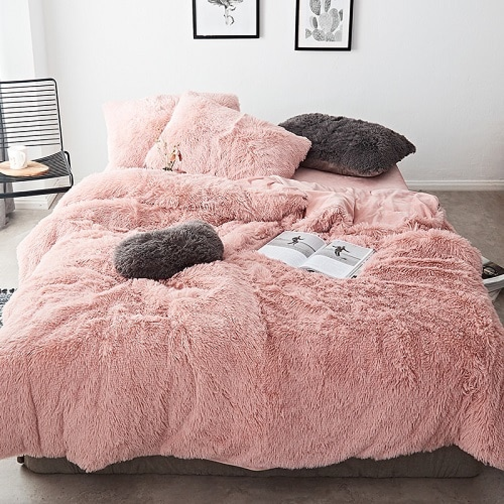 Parure de lit effet fourrure rose, bonne qualité et à la mode sur un lit dans une maison