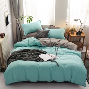 Parure de lit bicolore bleue-grise. Bonne qualité, confortable et à la mode sur un lit dans une maison