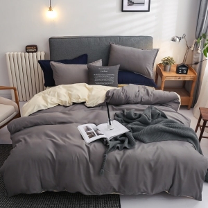 Parure de lit bicolore grise-beige, bonne qualité et très confortable sur un lit dans une maison