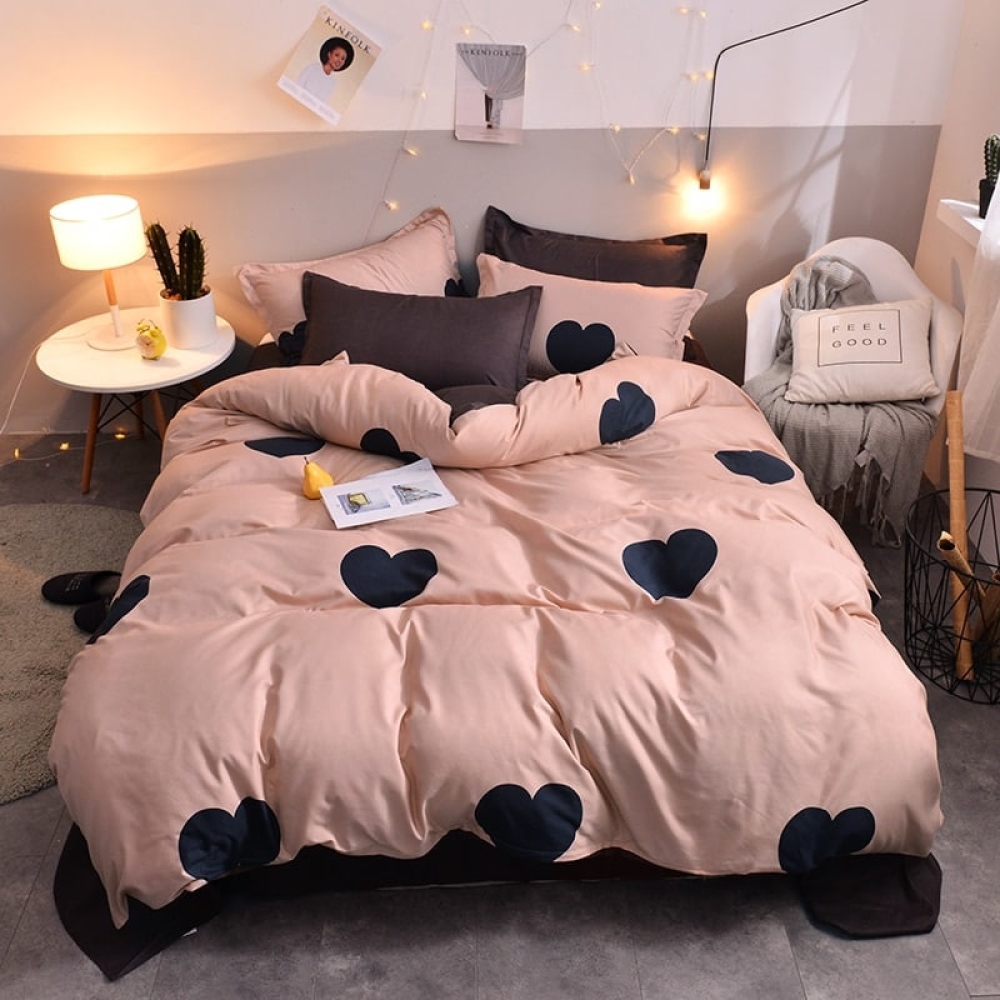Parure de lit rose et coeurs noirs. Bonne qualité, confortable et à la mode sur un lit dans une maison