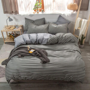Parure de lit à rayures noires et blanches, bonne qualité et à la mode sur un lit dans une maison