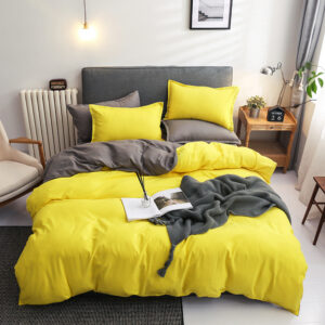 Parure de lit bicolore jaune-grise, bonne qualité et très confortable sur un lit dans une maison