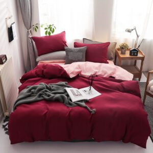 Parure de lit bicolore rose-bordeaux, bonne qualité et très confortable sur un lit dans une maison
