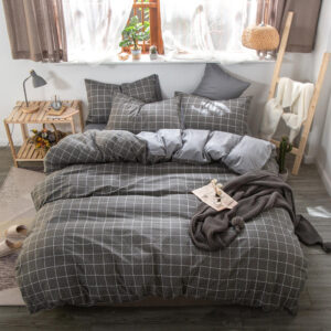 Parure de lit carreaux anthracites, bonne qualité, confortable, à la mode sur un lit dans une maison