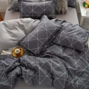 Parure de lit grise à carreaux, bonne qualité, très originale sur un lit dans une maison.
