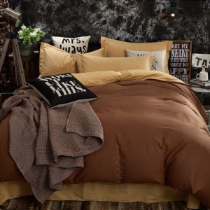 Parure de lit beige et marron. Bonne qualité, confortable et à la mode sur un lit dans une maison