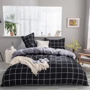 Parure de lit noir et blanc à carreaux. Bonne qualité, confortable et à la mode sur un lit dans une maison