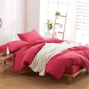Parure de lit unie rouge framboise. Bonne qualité, confortable et à la mode sur un lit dans une maison