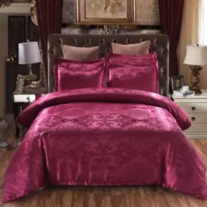 Parure de lit royale rouge framboise. Bonne qualité sur un lit dans une maison