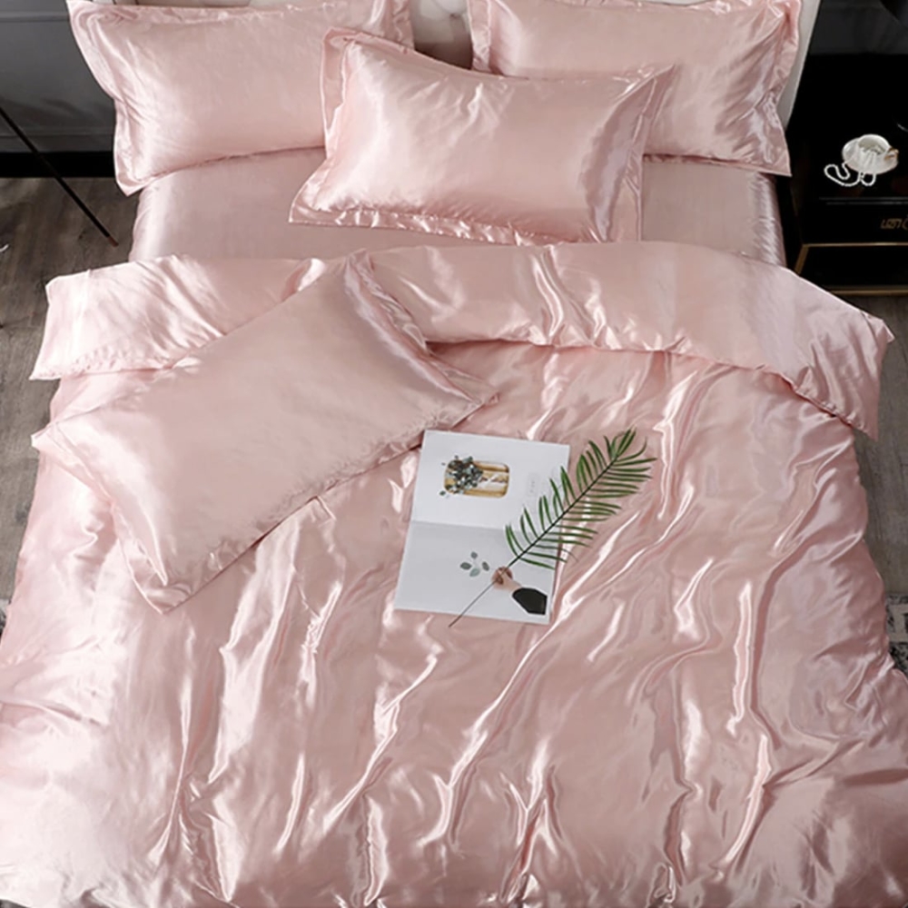 Parure de lit en satin de soie rose. Bonne qualité, confortable et à la mode sur un lit dans une maison