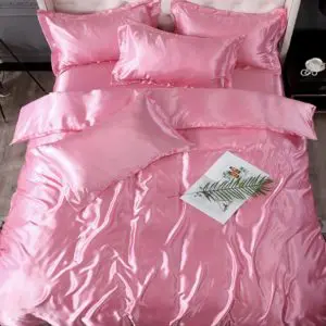 Parure de lit en satin de soie rose barbie. Bonne qualité, confortable et à la mode sur un lit dans une maison