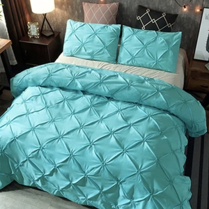 Parure de lit turquoise à effet matelassé. Bonne qualité, confortable et à la mode sur un lit dans une maison