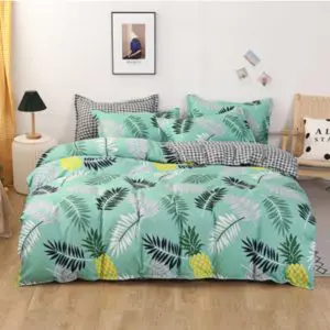 Parure de lit feuilles tropicales et ananas. Bonne qualité, confortable et à la mode sur un lit dans une maison