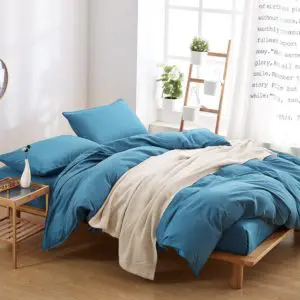 Parure de lit unie bleu canard. Bonne qualité, confortable et à la mode sur un lit dans une maison