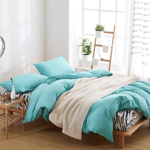 Parure de lit unie turquoise. Bonne qualité, confortable et à la mode sur un lit dans une maison