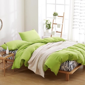 Parure de lit unie vert anis. Bonne qualité, confortable et à la mode sur un lit dans une maison