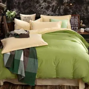 Parure de lit verte et beige. Bonne qualité et confortable et à la mode sur un lit dans une maison