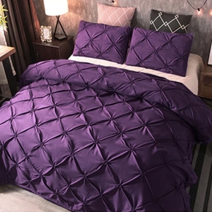 Parure de lit violette à effet matelassé. Bonne qualité et confortable et à la mode sur un lit dans une maison