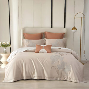 Parure de lit style asiatique beige sur un lit deux places avec le coussins assortis. Le mur côté tête de lit est blanc, une lampe portée à droite et un petit élément à gauche.