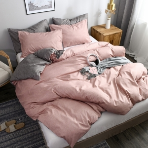 Parure de lit rose et grise, bonne qualité et à la mode, sur un lit dans une maison