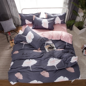 Parure de lit rose et grise à fleurs. Bonne qualité, confortable et à la mode sur un lit dans une maison