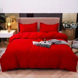Parure de lit unie rouge. Bonne qualité, confortable et à la mode sur un lit dans une maison