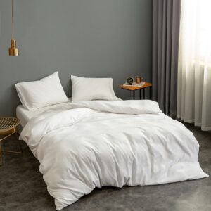 Parure de lit unie blanche. Bonne qualité, confortable et à la mode sur un lit dans une maison