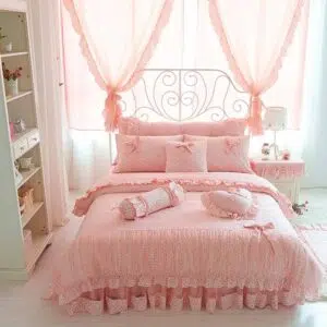 Parure de lit rose avec dentelle et motif nœud. Bonne qualité, confortable et à la mode sur un lit dans une maison