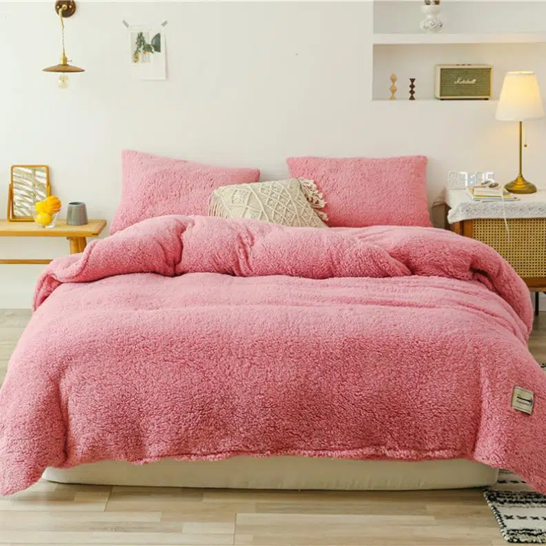 Parure de lit rose saumon effet fourrure. Bonne qualité, confortable et à la mode sur un lit dans une maison