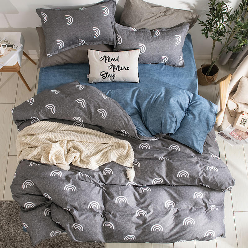 Parure de lit grise arcs-en-ciel, bonne qualité et à la mode sur un lit dans une maison