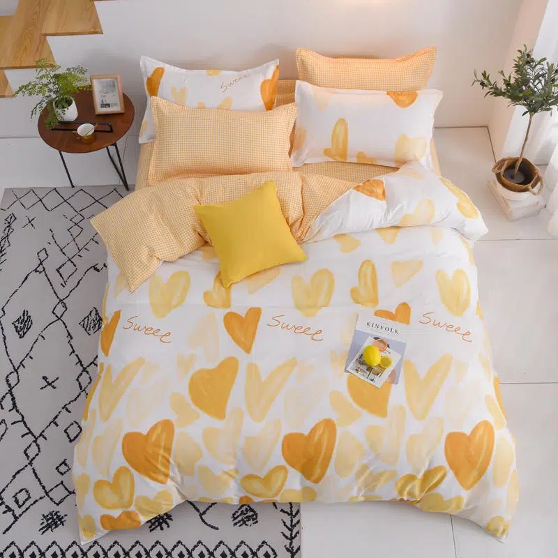 Parure de lit coeurs oranges, bonne qualité et à la mode sur un lit dans une maison