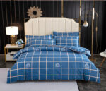 Parure de lit bleue à carreaux chique en tissu. Bonne qualité, confortable et à la mode sur un lit dans une maison