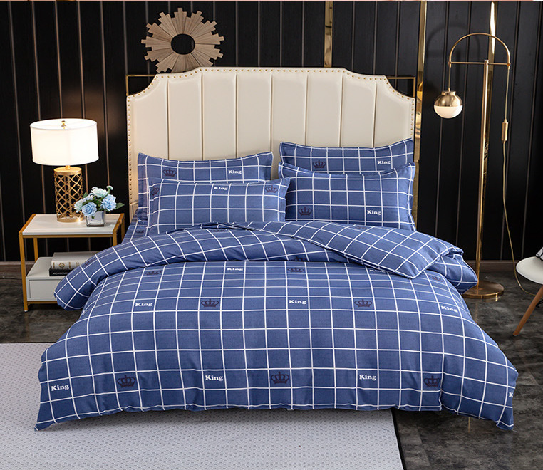 Parure de lit bleue à carreaux motif king. Bonne qualité, confortable et à la mode sur un lit dans une maison
