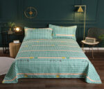 Parure de lit verte à carreaux chique en tissu. Bonne qualité, confortable et à la mode sur un lit dans une maison