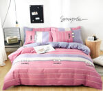 Parure de lit rose stylée motif happy en tissu. Bonne qualité, confortable et à la mode sur un lit dans une maison