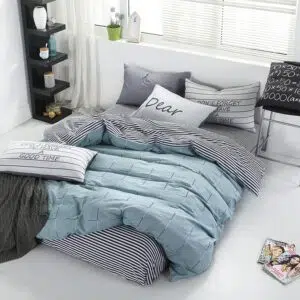 Parure de lit bleue motif carreaux en satin. Bonne qualité, confortable et à la mode sur un lit dans une maison