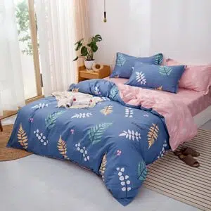 Parure de lit bleue motif feuilles. Bonne qualité, confortable et à la mode sur un lit dans une maison