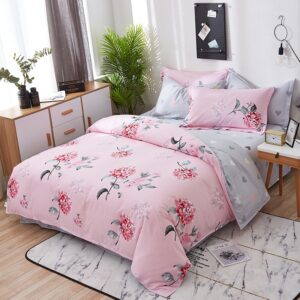 Parure de lit rose et grise en coton imprimé fleuri. Bonne qualité, confortable et à la mode sur un lit dans une maison