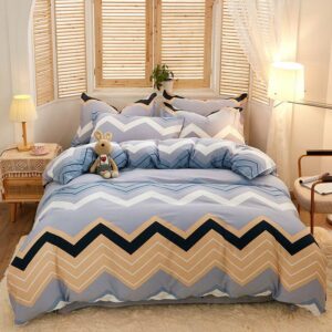 Parure de lit grise à rayures multicolores en zig zag. Bonne qualité, confortable et à la mode sur un lit dans une maison