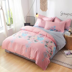 Parure de lit rose et grise avec imprimé fleuri. Bonne qualité, confortable et à la mode sur un lit dans une maison