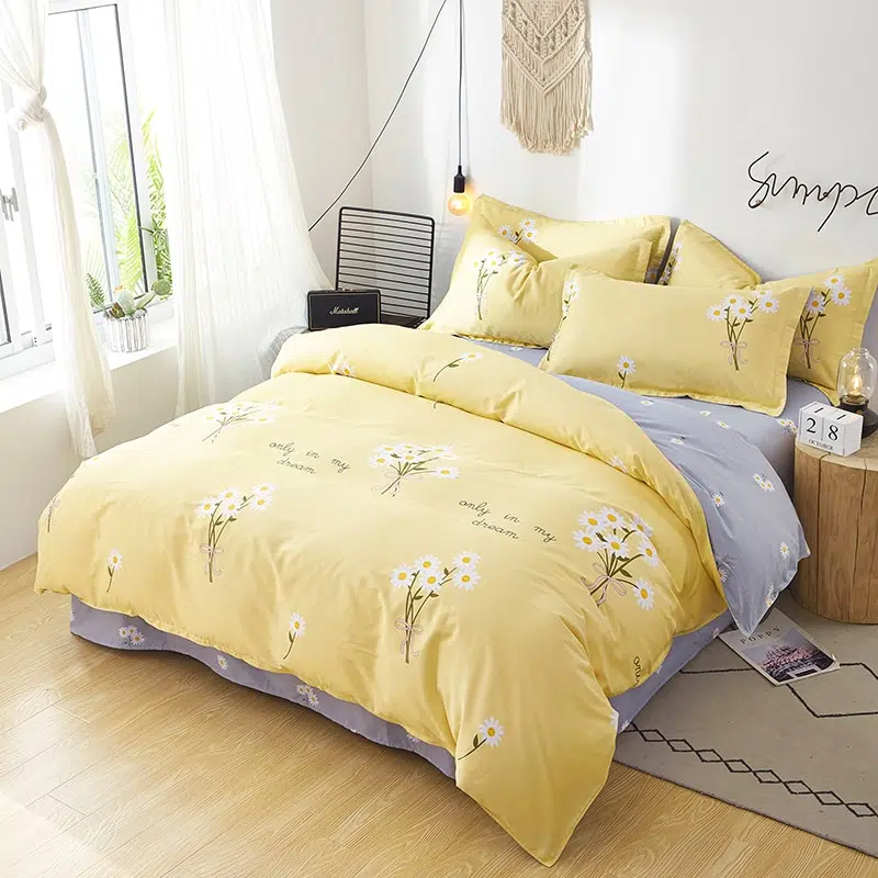 Parure de lit jaune motif fleurs blanches. Bonne qualité, confortable et à la mode sur un lit dans une maison