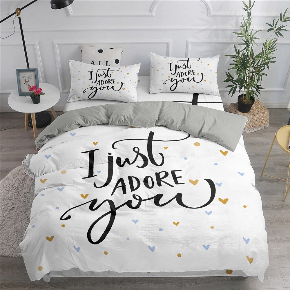 Parure de lit blanche avec inscription « I just adore you ». Bonne qualité, confortable et à la mode sur un lit dans une maison