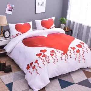 Parure de lit blanche à motif cœurs rouges. Bonne qualité, confortable et à la mode sur un lit dans une maison
