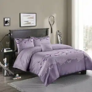 Parure de lit violette à motif floral blanc. Bonne qualité, confortable et à la mode sur un lit dans une maison