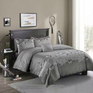 Parure de lit gris clair à motif floral blanc. Bonne qualité, confortable et à la mode sur un lit dans une maison
