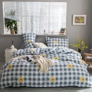 Parure de lit à motif carreaux et fleurs. Bonne qualité, confortable et à la mode sur un lit dans une maison