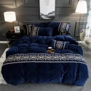 Parure de lit bleu nuit molletonné brodée. Bonne qualité, confortable et à la mode sur un lit dans une maison