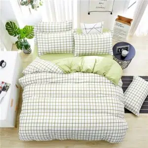 Parure de lit blanche à motifs carreaux verts. Bonne qualité, confortable et à la mode sur un lit dans une maison